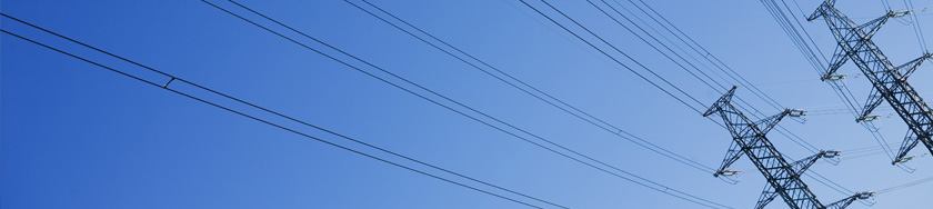 Lattice transmission towers and conductor spans against a clear blue sky